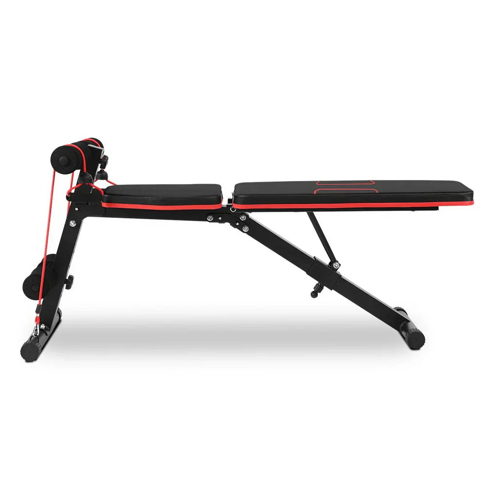 Black and red adjustable workout bench with resistance bands and foam rollers for home gym