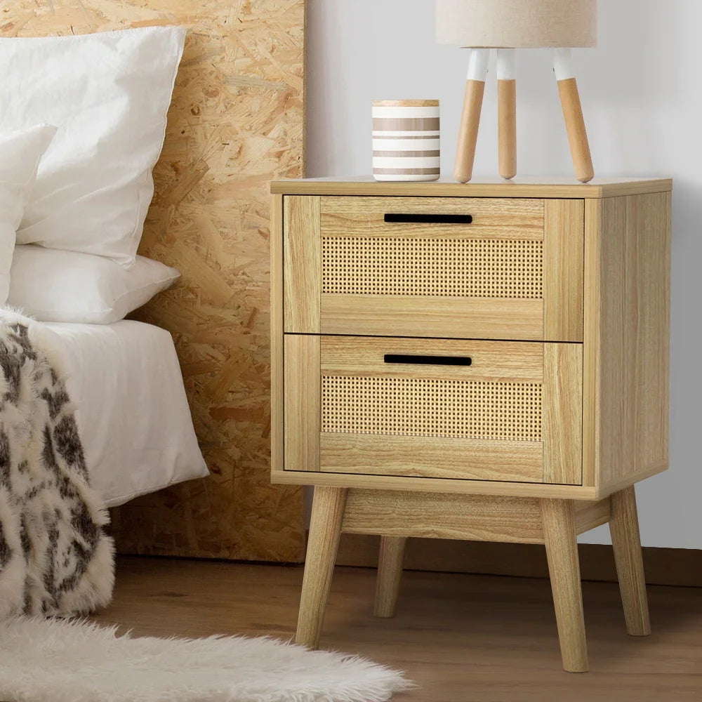 Modern oak bedside table with rattan drawer fronts in a cozy bedroom setting