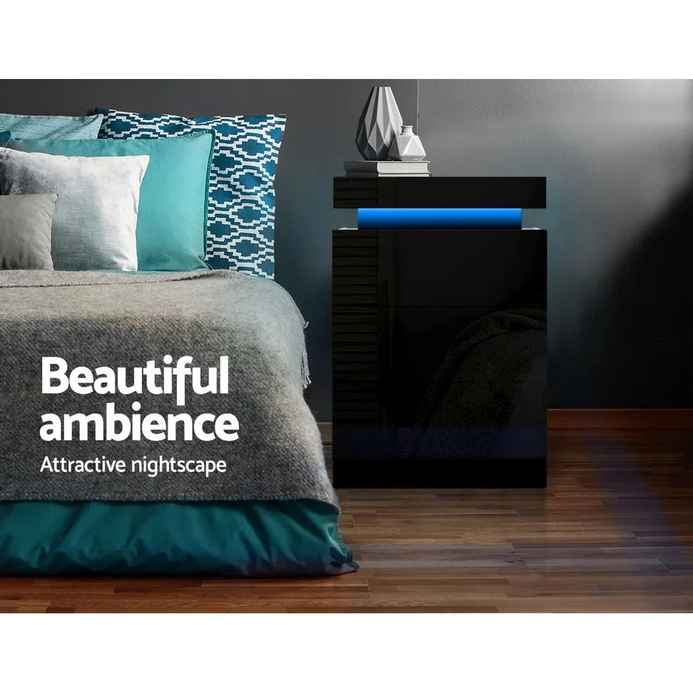 Modern black LED nightstand beside bed with patterned pillows and cozy bedding