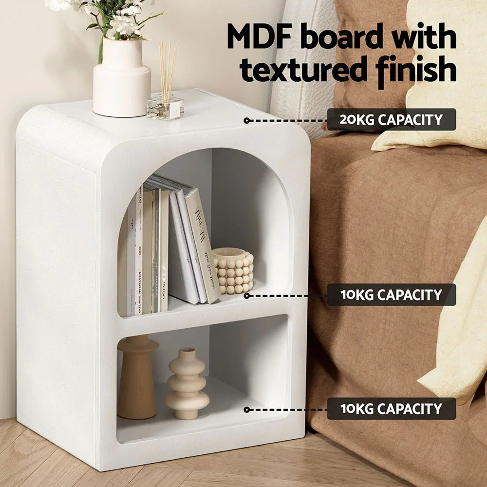 White MDF board bedside table with textured finish, books, and decor items in a modern bedroom.