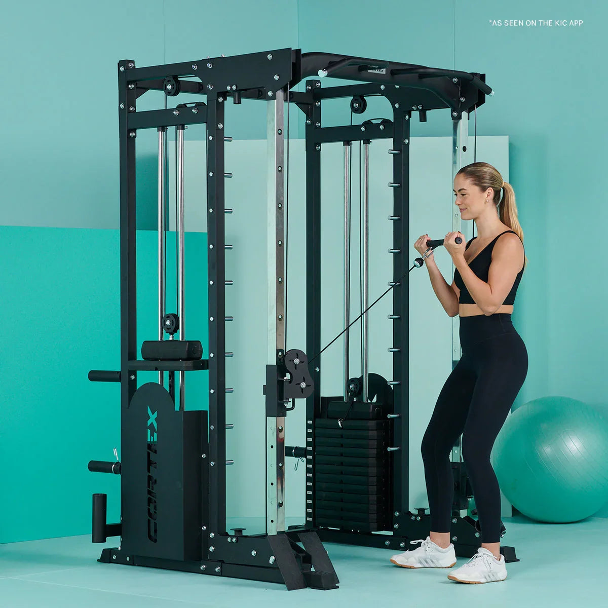 Woman using Cortex cable machine for bicep curls in modern home gym setting