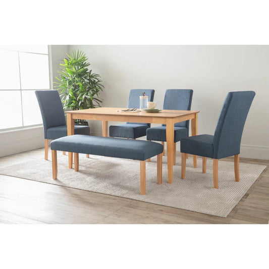 Modern dining table set with blue upholstered chairs and bench on a light rug