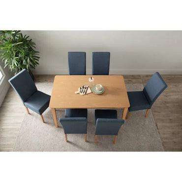 Modern dining room with light wood table, six blue chairs, dishes, and plant on rug