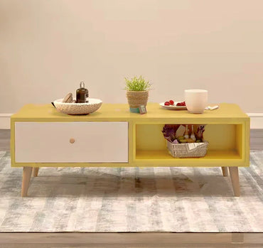 Modern yellow coffee table with white drawer, decor items, and basket on rug