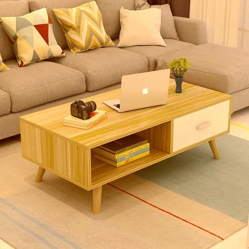 Modern wooden coffee table with books, laptop, camera and vase in a cozy living room