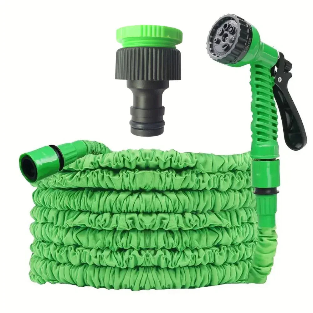 Expandable green garden hose with adjustable spray nozzle and black connector fitting