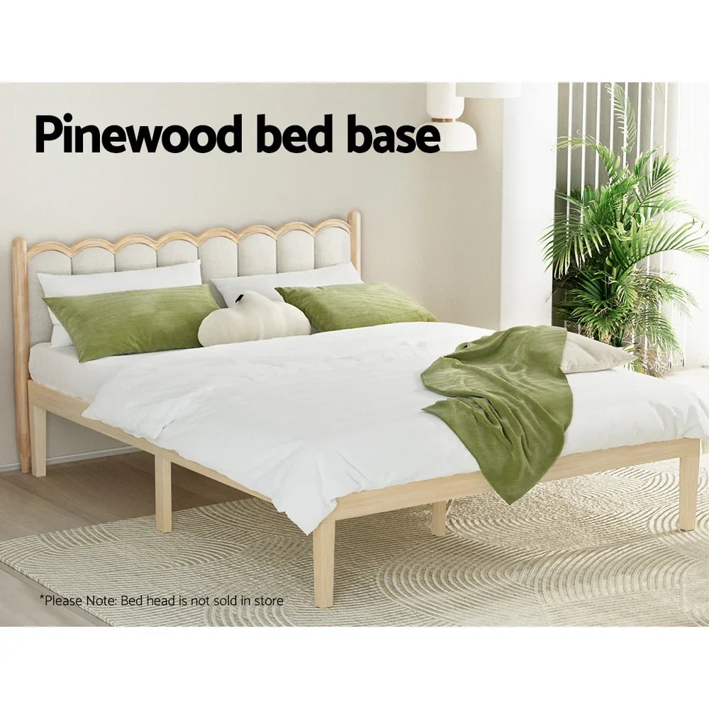Pinewood bed base with white bedding and green pillows in a bright, modern bedroom