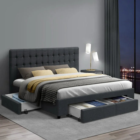 Modern dark gray fabric storage bed with tufted headboard, open drawers, and nightstand lamp in bedroom