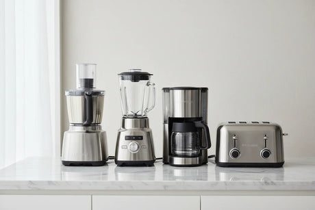 Stainless steel kitchen appliances set with food processor, blender, coffee maker, and toaster on marble countertop