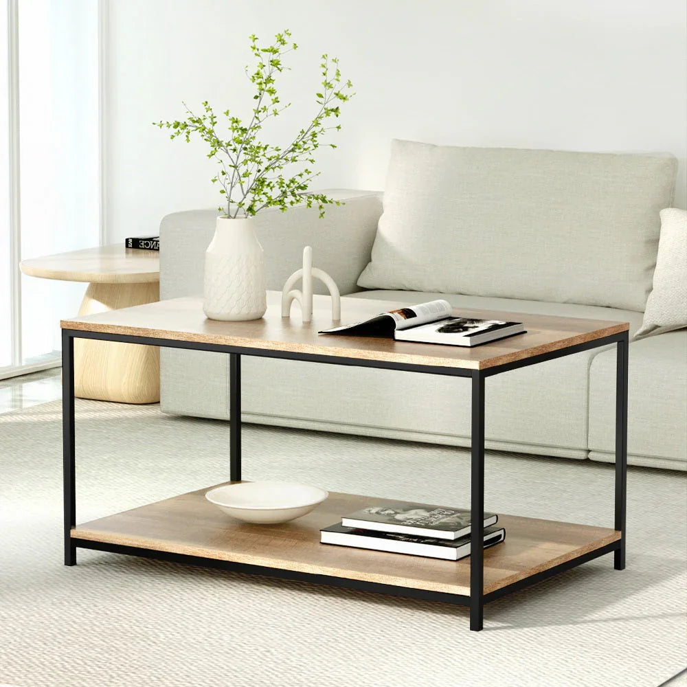 Modern wooden coffee table with black frame in minimalist living room, styled with books and vase
