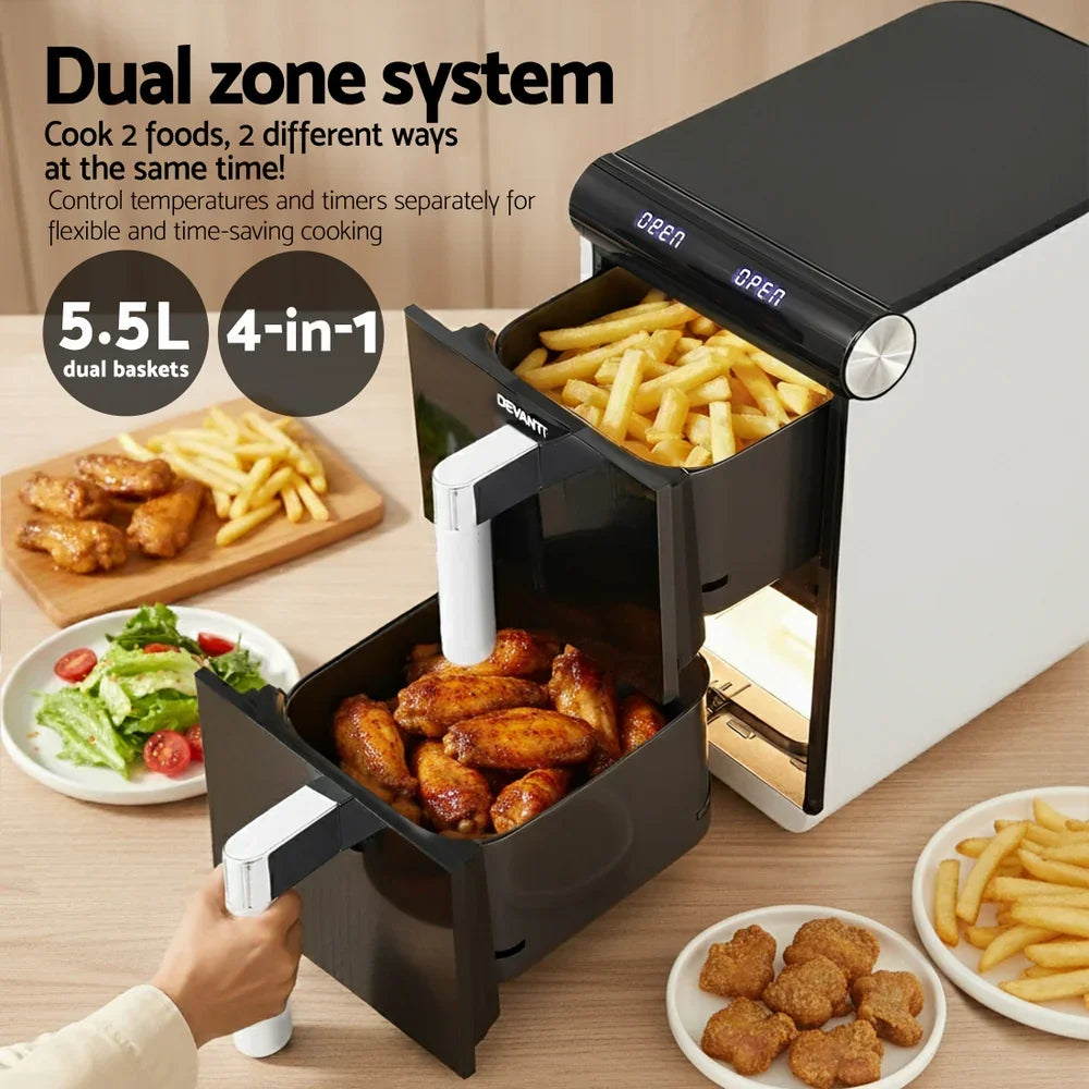 Dual zone air fryer with open baskets cooking fries and chicken wings, surrounded by food plates.