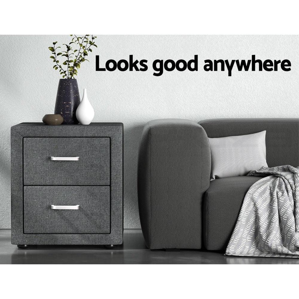 Modern grey nightstand with decorative vases beside a grey sofa and pillow in a minimalist room