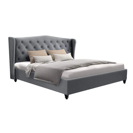 Modern gray upholstered bed with button-tufted wingback headboard and beige pillows