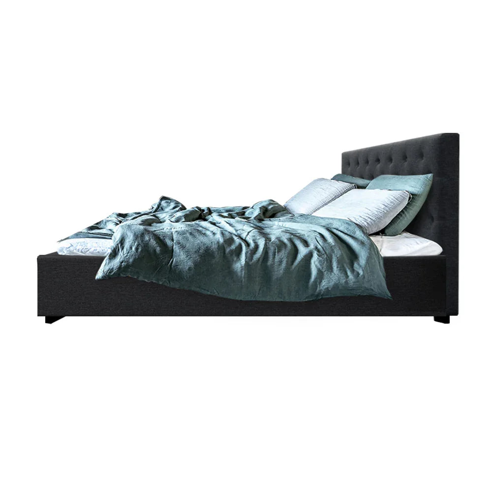 Modern dark gray upholstered bed with tufted headboard, light blue pillows, and teal bedding