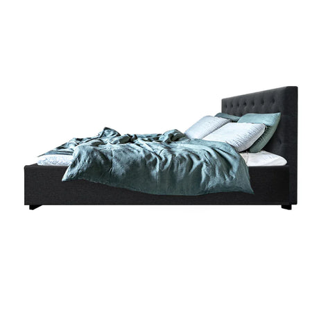 Modern dark gray upholstered bed with tufted headboard, light blue pillows, and teal bedding