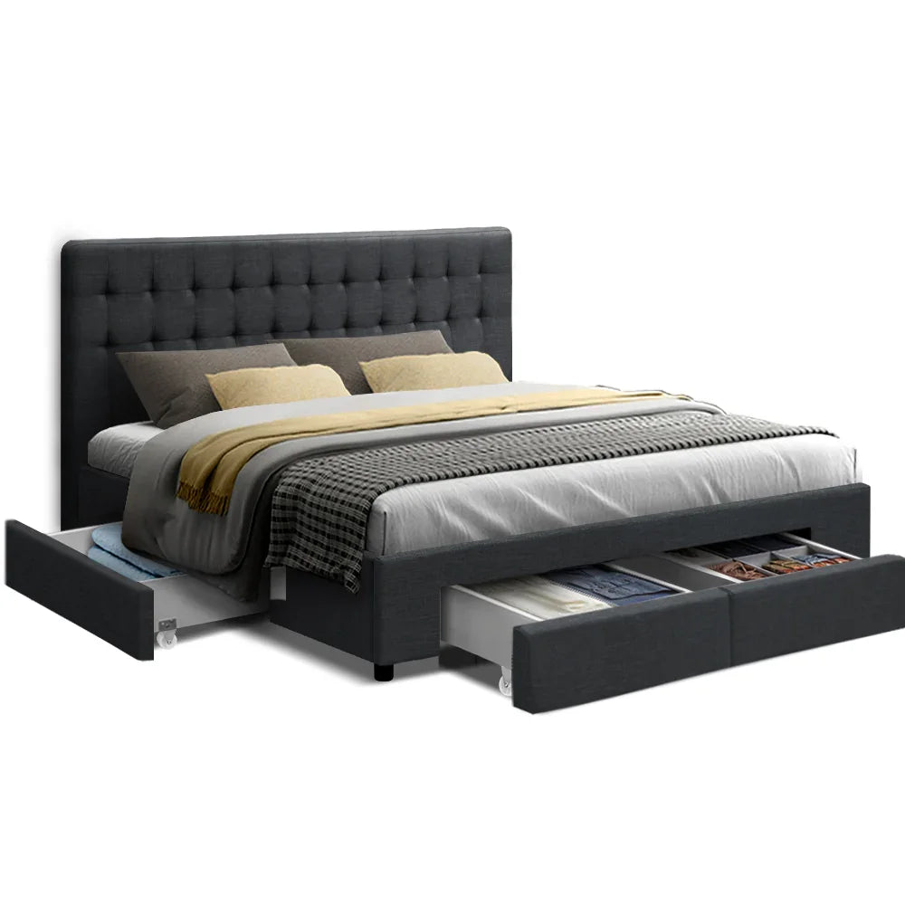 Modern dark gray upholstered bed with tufted headboard and under-bed storage drawers filled with clothes