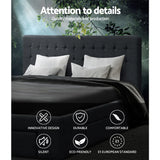 Dark gray upholstered bed with white pillows and black bedding under green leafy branches with quality and design icons