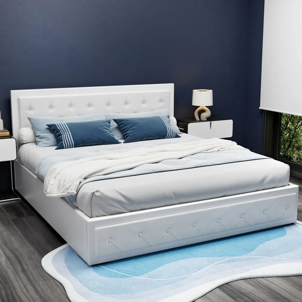 Modern white upholstered bed with tufted headboard, blue pillows, white blanket, beside nightstands in navy blue bedroom