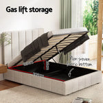 Beige upholstered gas lift storage bed with lifted mattress showing black non-woven fabric storage space