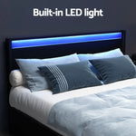 Modern bed with built-in blue LED light in black headboard and grey-blue bedding