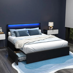Modern bedroom with black platform bed featuring LED headboard, blue pillows, and under-bed storage drawer