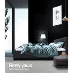 Modern bedroom with dark walls, grey upholstered bed, teal bedding, and ambient lighting