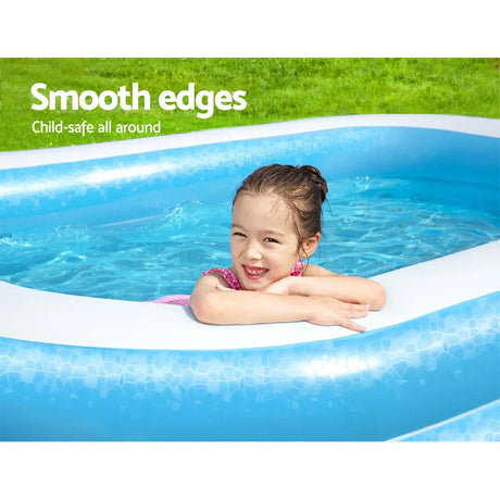 Smiling girl in pink swimsuit leaning on edge of blue inflatable pool in sunny backyard