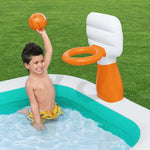 Child playing basketball with inflatable hoop in a backyard pool with green grass