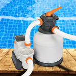 White and black sand filter pump with orange valves on wood deck by a blue tiled swimming pool