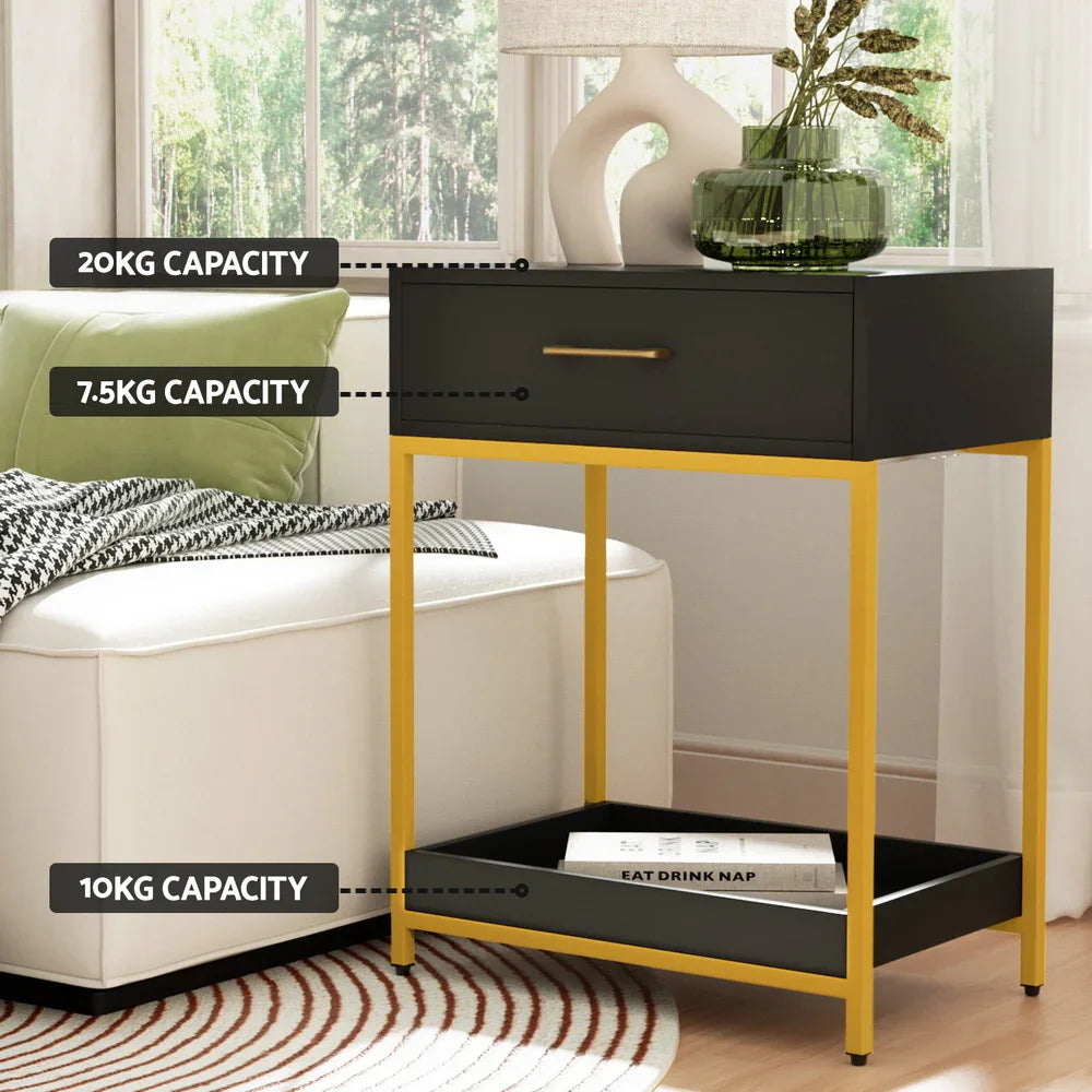 Modern black and gold side table with labeled weight capacities, by sofa and window.
