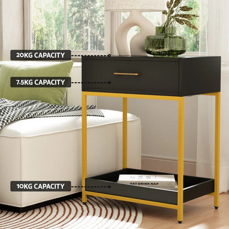 Modern black and gold side table with labeled weight capacities, by sofa and window.