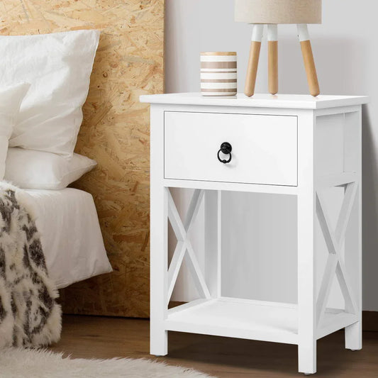 White wooden nightstand with drawer, table lamp, and decor in cozy bedroom setting