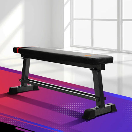 Flat workout bench in a bright gym with modern geometric flooring