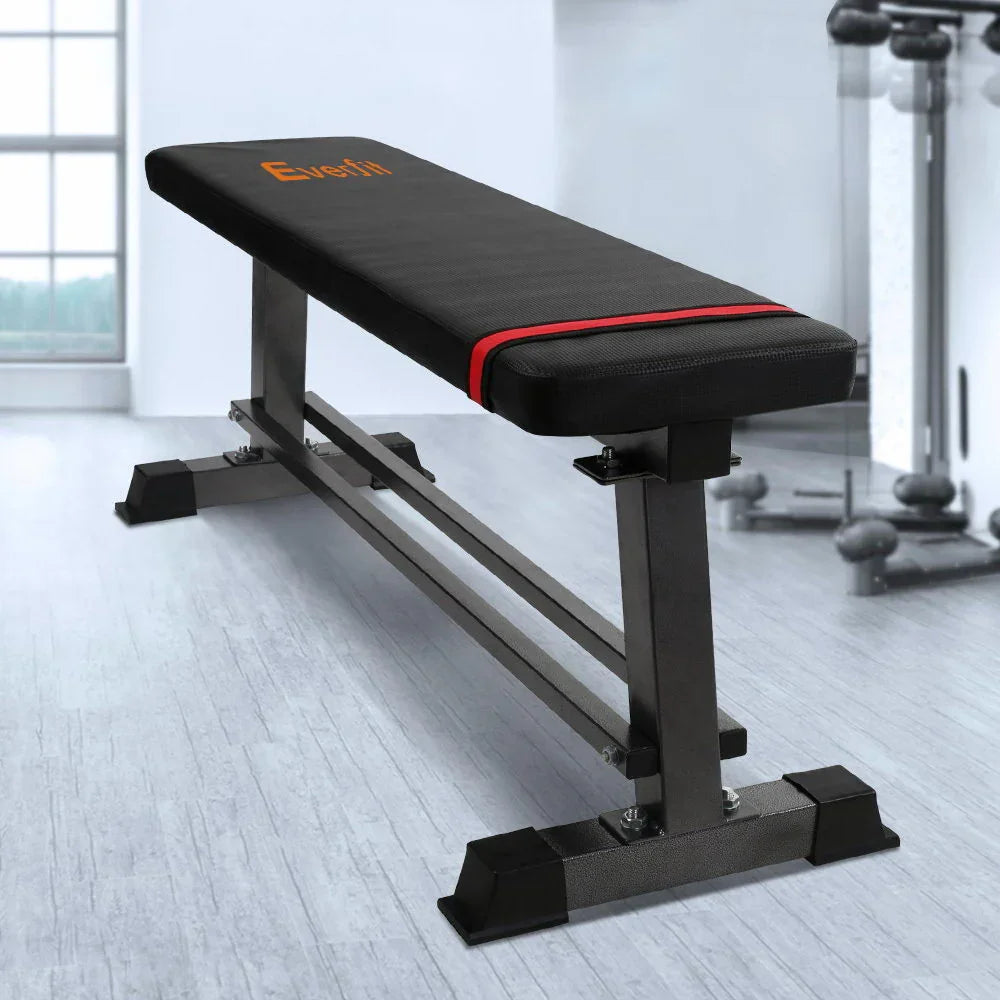Flat Everfit weight bench with black padding and red stripe in a gym setting