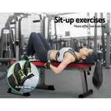 Woman performing sit-up exercises on red gym bench with ankle strap in fitness center