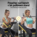 Woman using adjustable preacher curl bench and lat pulldown stand in gym setting