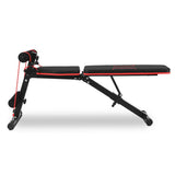 Black and red adjustable workout bench with resistance bands and foam rollers for home gym