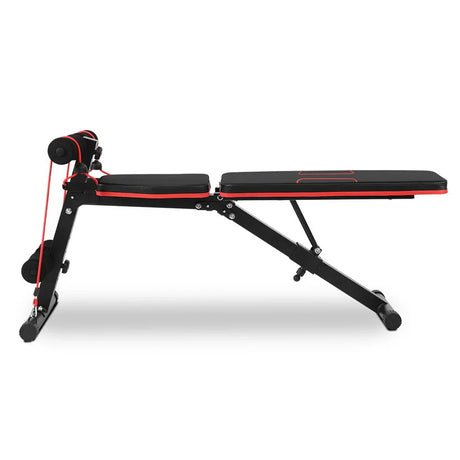 Black and red adjustable workout bench with resistance bands and foam rollers for home gym