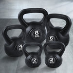 Set of black kettlebells weighing 2kg, 4kg, 6kg, and 8kg on a wood floor