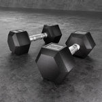 Pair of black 10kg hex dumbbells with silver textured grips on gray textured floor