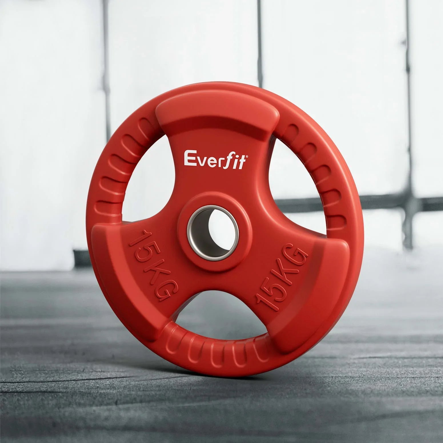 Red Everfit 15kg rubber coated weight plate on gym floor with grip handles