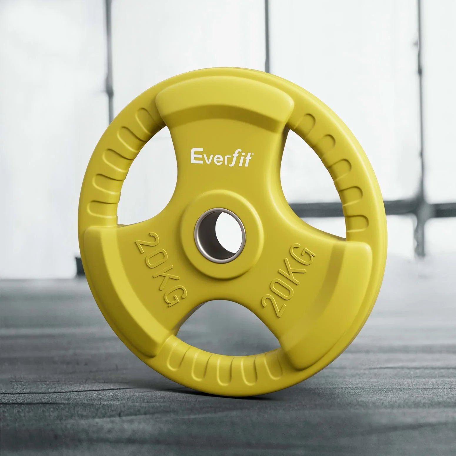 Yellow Everfit 20kg weight plate with ergonomic grip handles on gym floor