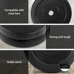 Black 10kg weight plates with labels showing compatibility, durability, and stable stand on wooden floor