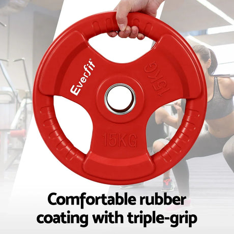 Red Everfit 15kg rubber-coated weight plate with triple grip held in hand, gym background