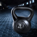 Black 16kg kettlebell on textured gym floor with dark fitness studio background