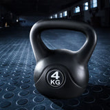 Black 4 kg kettlebell on textured gym floor with industrial workout space background