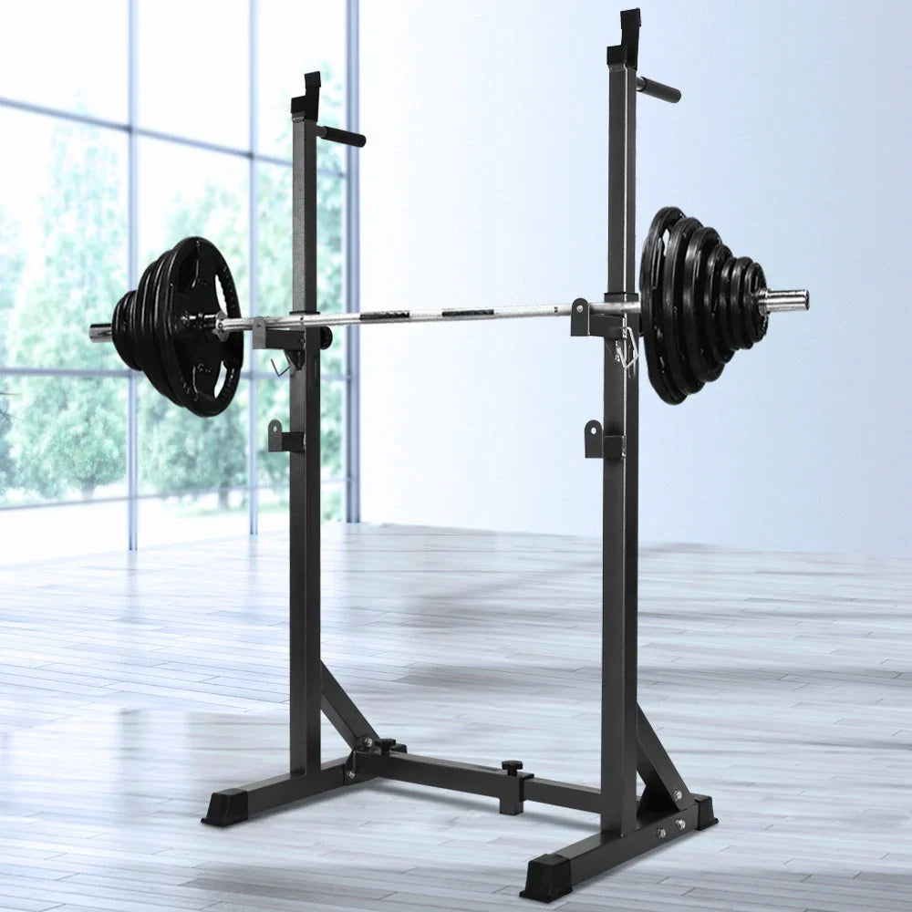 Adjustable squat rack with loaded barbell in a bright gym with large windows