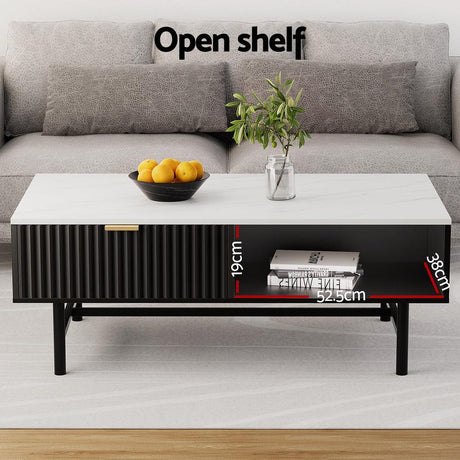 Modern coffee table with open black shelf, white top, sofa, and decor in living room
