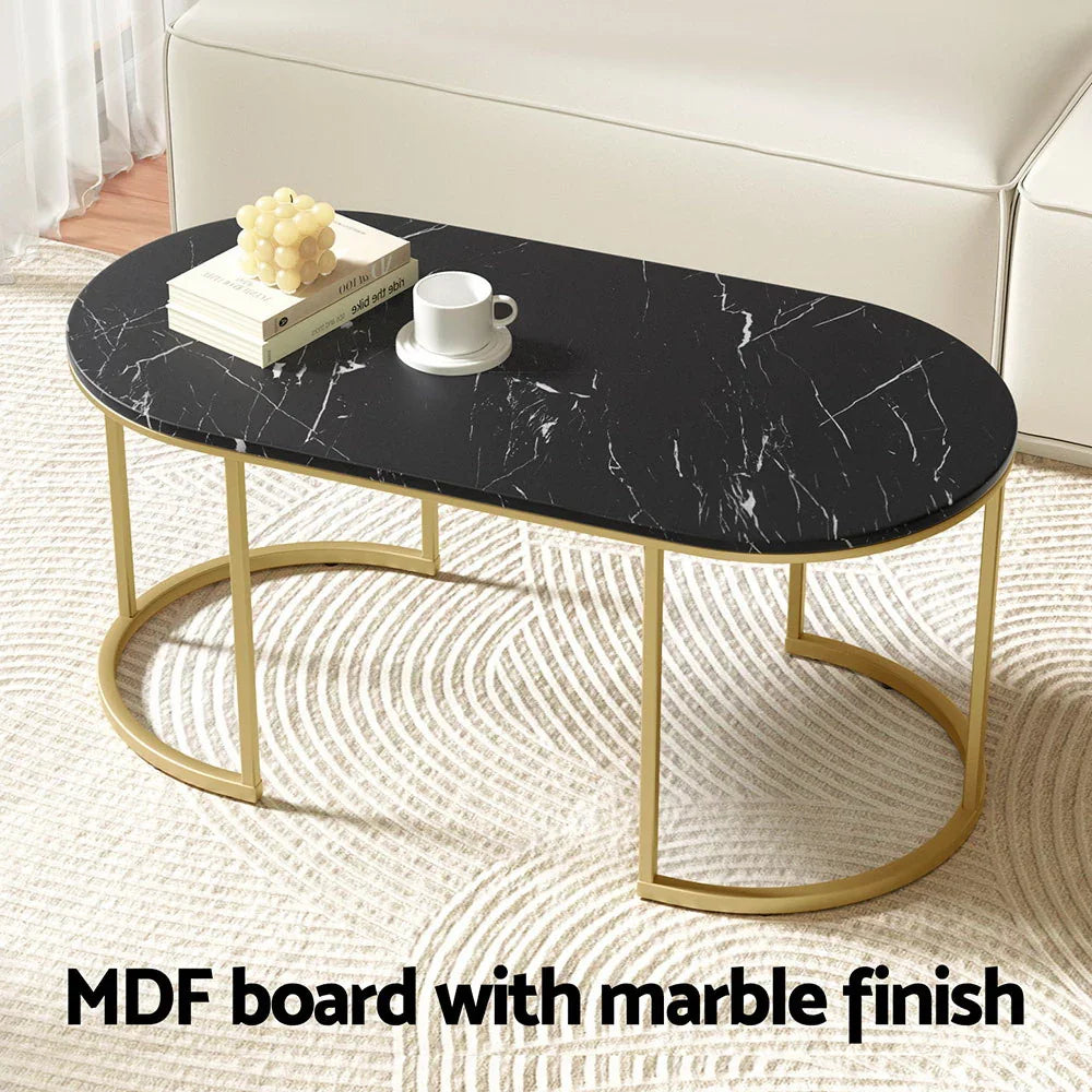 Modern black marble finish coffee table with gold metal legs in living room setting