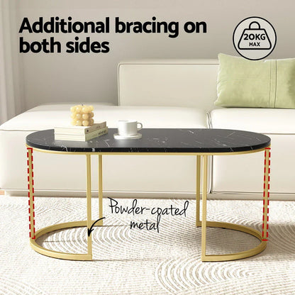 Black marble oval coffee table with gold powder-coated metal legs in modern living room.